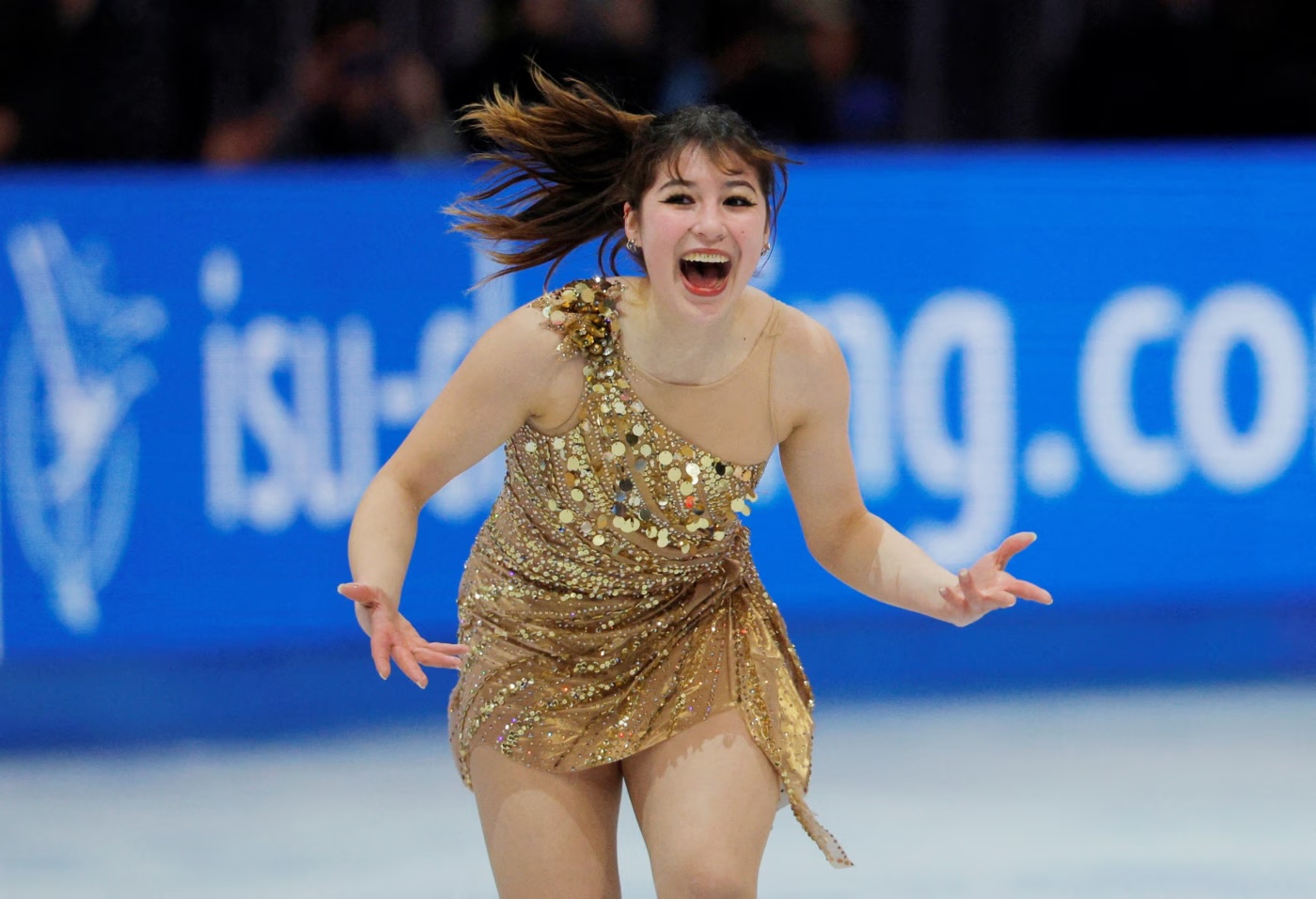 Alyssa Liu happy skating in gold dress. 